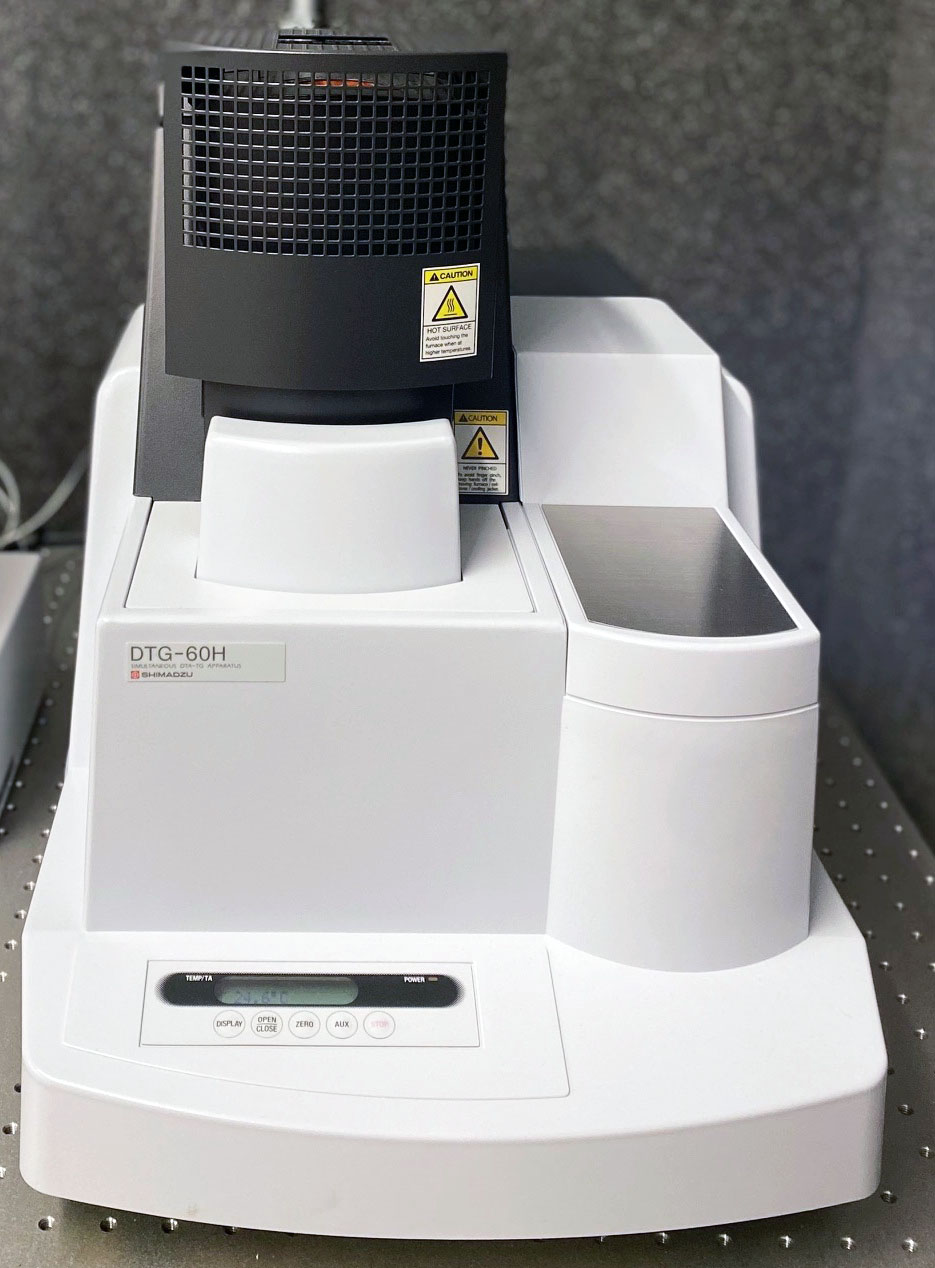 Shimadzu DTG-60H thermogravimetric analyzer with high-temperature furnace and warning labels.
